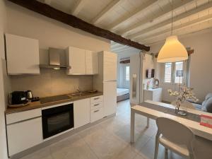 a kitchen with white cabinets and a dining table at Monza Downtown House Via Bartolomeo Zucchi 5 Monza in Monza