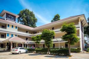 a hotel with a car parked in front of it at Baan Mak Mai Hotel in Si Sa Ket