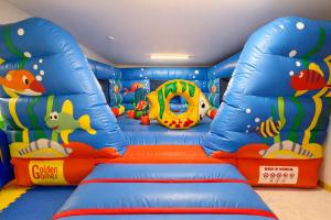 a childrens play room with a blue inflatable room with a fish at Hotel Regal in Rimini