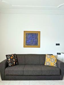 a couch in a living room with a painting on the wall at 2 chambres tout confort - calme absolue in Temara +1 photo
