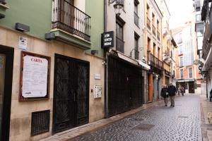 a couple of people walking down a street at León Center Rooms in León +31 photos
