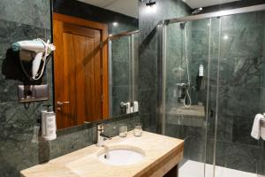 a bathroom with a sink and a shower at León Center Rooms in León
