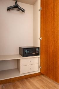 a microwave sitting on a shelf in a room at León Center Rooms in León