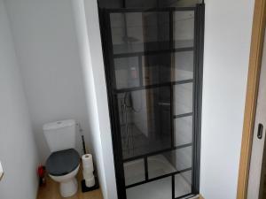 a bathroom with a toilet and a glass cabinet at Cozyhouse in Touquet Berthe