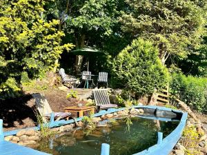 a garden with a pond and two chairs and a table at Glenshee Suite, Beechtree Cottage in Kirkmichael +1 photo