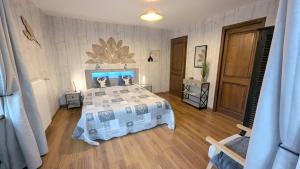 a bedroom with a large bed and a wooden floor at Les Grands Champs in Attignat-Oncin