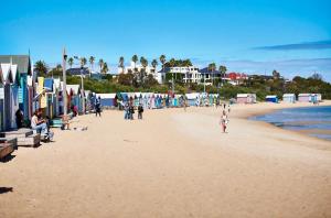 a group of people walking on a beach at Hampton Beach House in Melbourne
