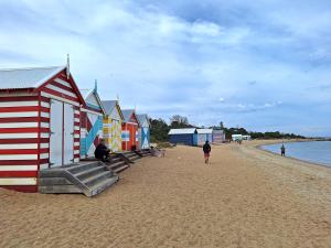 a row of colorful beach huts on a beach at Hampton Beach House in Melbourne +8 photos