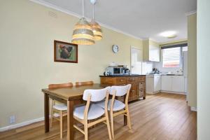 a kitchen with a dining room table and chairs at Hampton Beach House in Melbourne