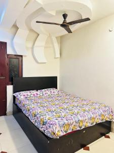 a bed in a room with a ceiling fan at DIAMOND PALACE Kalasipalya in Bangalore