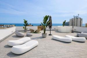 a patio with white furniture on a roof at Hotel Regal in Rimini
