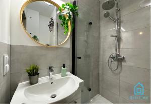 a bathroom with a sink and a shower and a mirror at Piggy Room - 3 km to Baltic Sea in Gdańsk