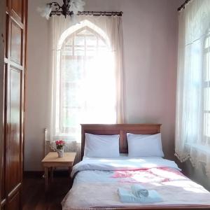a bedroom with a bed and a window with a towel on it at Frig Evi in Sabuncu