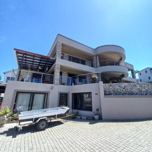 a large house with a truck parked in front of it at Whale Rock Guesthouse in Plettenberg Bay