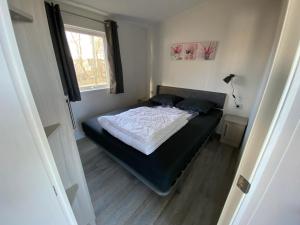 a bedroom with a bed in a room with a window at Chalet op Camping Mounewetter in Witmarsum +9 photos