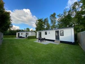 a large yard with two mobile homes at Chalet op Camping Mounewetter in Witmarsum