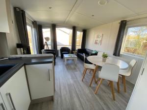 a kitchen and living room with a table and chairs at Chalet op Camping Mounewetter in Witmarsum