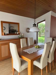 a dining room with a table and white chairs at Ferienhaus Altenplos in Heinersreuth