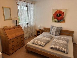 a bedroom with a bed with a red poppy painting on the wall at Ferienhaus Altenplos in Heinersreuth