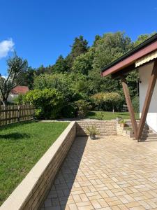 a patio with a brick retaining wall and a fence at Ferienhaus Altenplos in Heinersreuth +6 photos