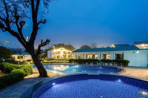 ein Swimmingpool vor einem Haus bei Nacht in der Unterkunft Baris river resort Corbett in Rāmnagar