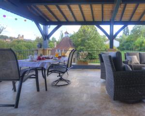 a patio with a table and chairs on a deck at La Villa du Mont in Gourdon