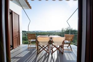 a balcony with a table and chairs on a deck at Mary's Panorama Houses in Gialova