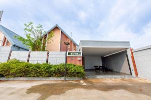 a house with a garage with a sign in front of it at TheH Pool Villa in Nong Prue