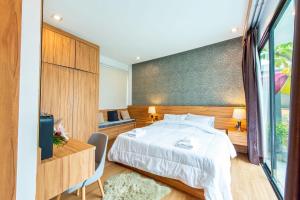 a bedroom with a large bed and a tv at TheH Pool Villa in Nong Prue +12 photos