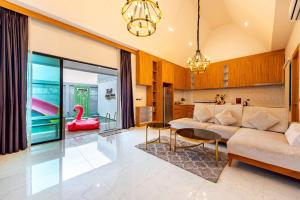a living room with a couch and a pink swan at TheH Pool Villa in Nong Prue