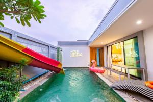 a pool with a slide in a house at TheH Pool Villa in Nong Prue