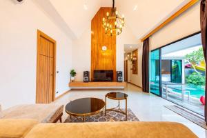a living room with a couch and a table at TheH Pool Villa in Nong Prue