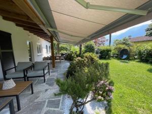 an outdoor patio with chairs and tables and a garden at Ascona Casa Cristina in Ascona