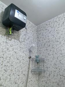 a shower in a bathroom with a wall at Pierdi Villa in Panundaan