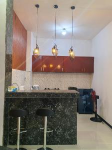 a kitchen with a black counter and pendant lights at Pierdi Villa in Panundaan