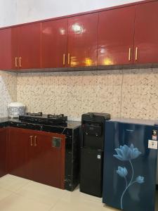 a kitchen with black appliances and red cabinets at Pierdi Villa in Panundaan