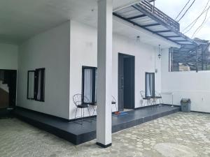 a white building with two chairs in a room at Pierdi Villa in Panundaan +2 photos
