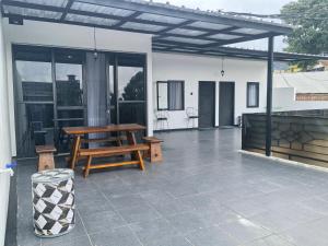 a patio with a wooden bench and a table at Pierdi Villa in Panundaan