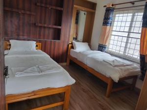 a bedroom with two beds and a window at A Square Residency Inn in Pokhara