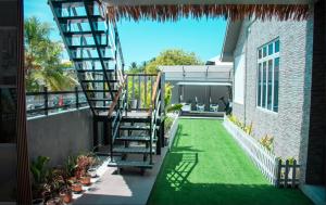 a patio with green grass and stairs on a building at Sunset Private Villa in Bandara