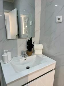 a white bathroom with a sink and a mirror at Cantinho da Nina in Arcos de Valdevez +12 photos