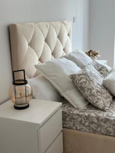 a bed with white pillows and a vase on a table at Cantinho da Nina in Arcos de Valdevez
