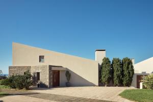 a modern house with a stone facade at Villa Dei Sogni, for the Design Lovers,By ThinkVilla in Agia Pelagia