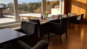 a dining room with tables and chairs and a large window at Hotel Harmonie in Luhačovice