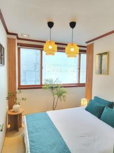 a bedroom with a large bed and two windows at 대구 K Stay in Daegu