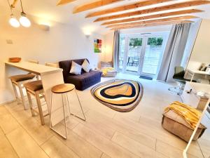 a living room with a table and a couch at Modern self contained tiny home with patio in Loughton