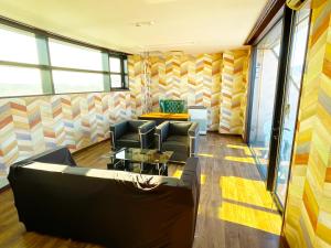 a waiting room with a couch and chairs at ゲストハウス 清水銀座 in Shizuoka