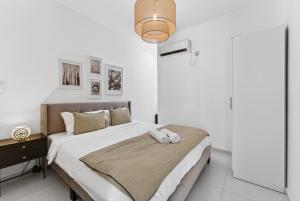 a bedroom with a large bed with white walls at Rooftop & Jacuzzi privé à 5 min de la plage in Flic-en-Flac +27 photos