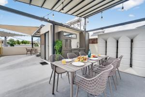 an outdoor patio with a table and chairs at Rooftop & Jacuzzi privé à 5 min de la plage in Flic-en-Flac