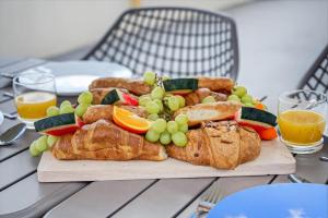 a plate of bread and fruit on a table at Rooftop & Jacuzzi privé à 5 min de la plage in Flic-en-Flac